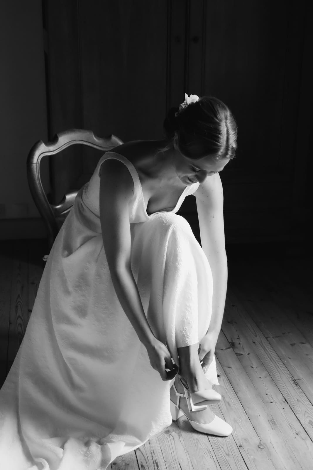 La mariée met ses chaussures, en noir et blanc