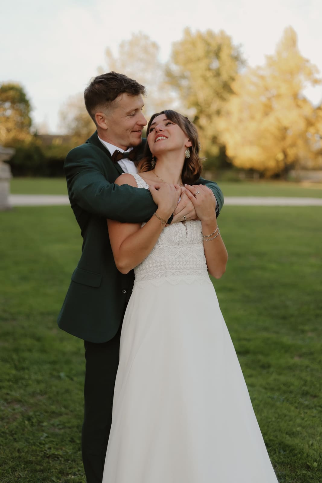 Couple de mariés enlacés au coucher du soleil
